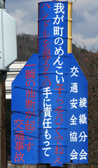 【写真1】遠野市綾織交差点の「めんこい子らをひくでねえ」（クリックで全体）